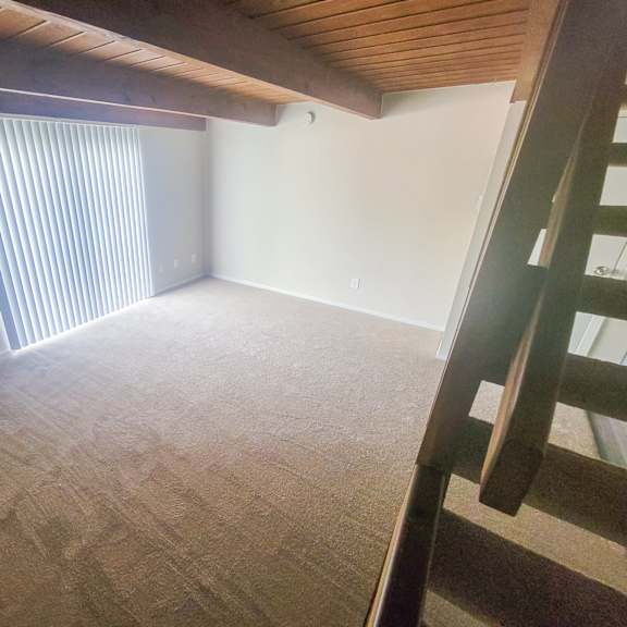 an empty attic with a ladder leading up to a loft