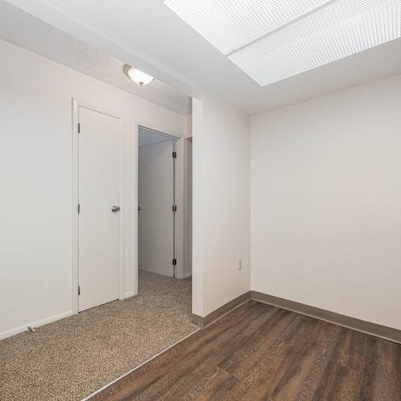 a room with a white door and a brown floor.