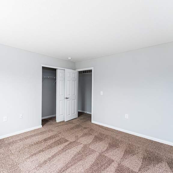 a room with a carpeted floor and a white door.