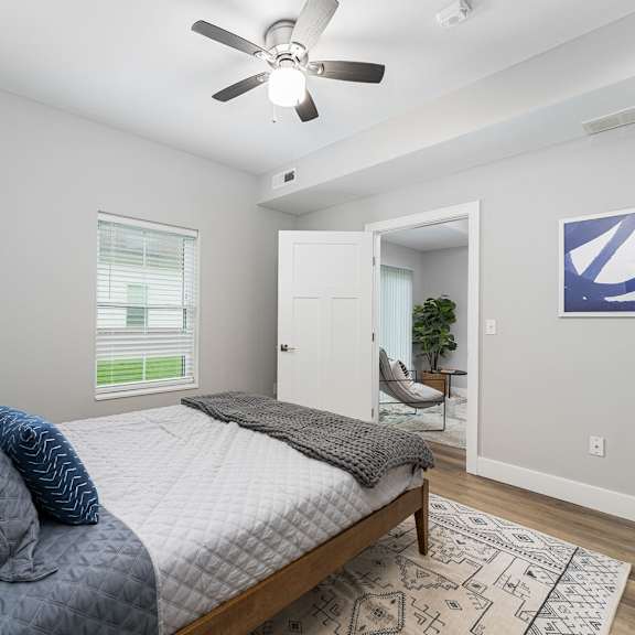a bedroom with a bed, a ceiling fan, and a rug.