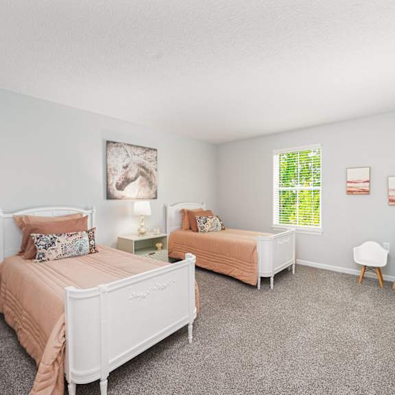 a bedroom with two beds and a window