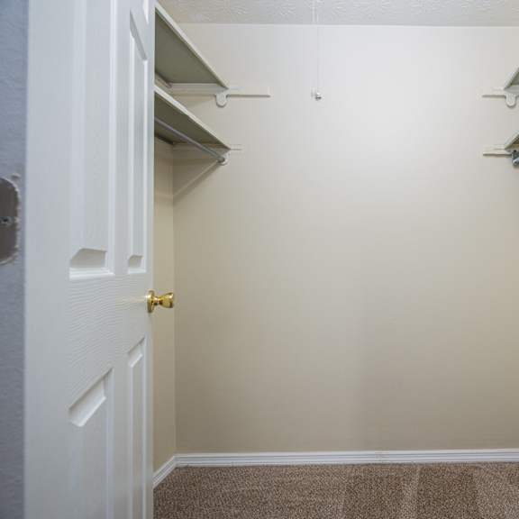 a white door with a gold handle is in a room with a brown carpet.