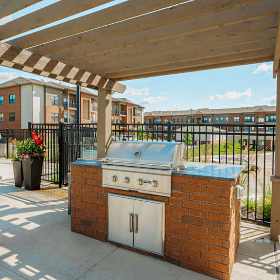 a patio with a barbecue grill and a pool