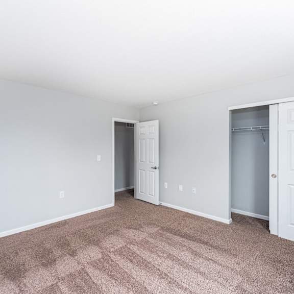 a room with a carpeted floor and two white doors.