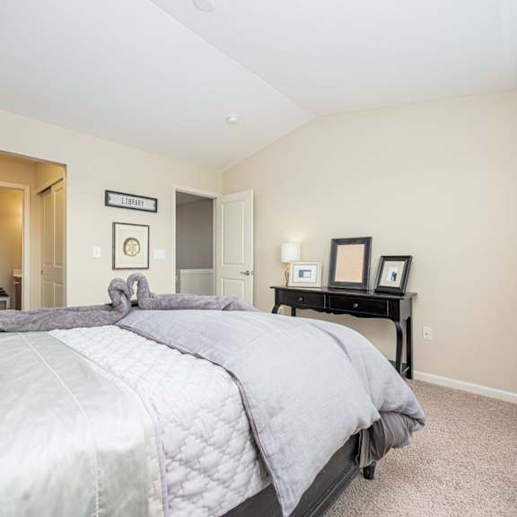 a bedroom with a large bed and a nightstand with a lamp.