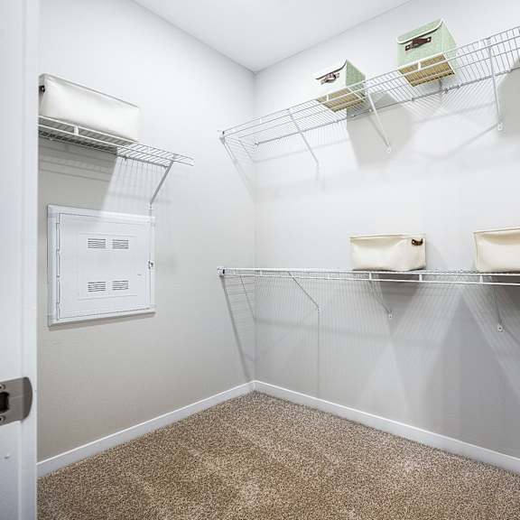 a spacious closet with shelves and a dryer in the corner of the room