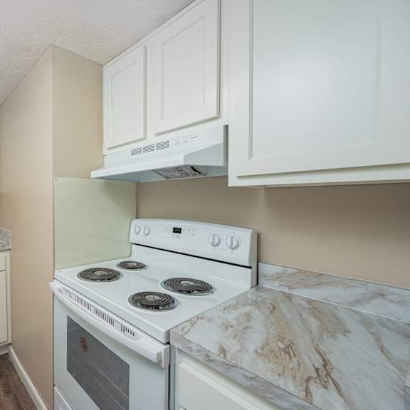 a kitchen with white appliances and marble counter tops
