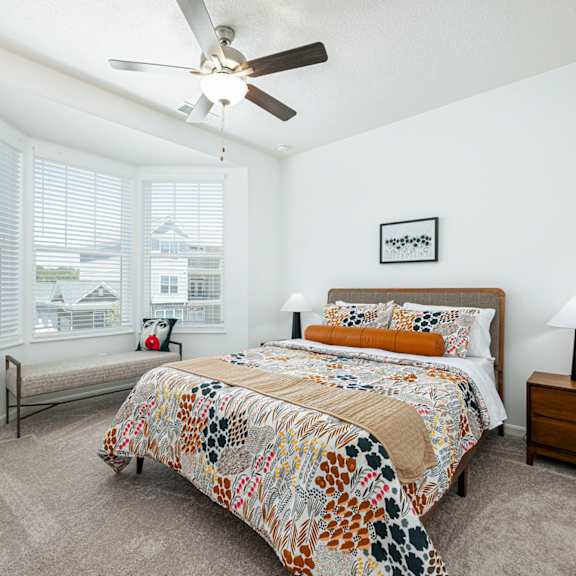 a bedroom with a bed and a ceiling fan