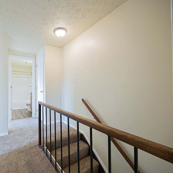 a hallway with a staircase and a light on the ceiling.