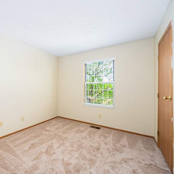 a room with carpet and a door and a window
