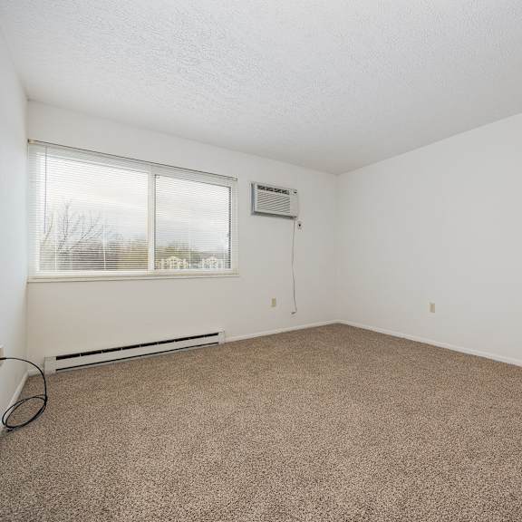 a room with a carpeted floor and a window.