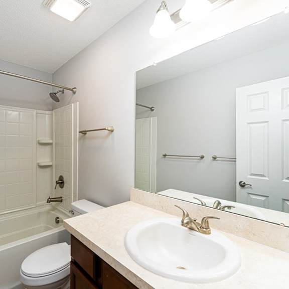 a white bathroom with a sink, toilet, and bathtub.