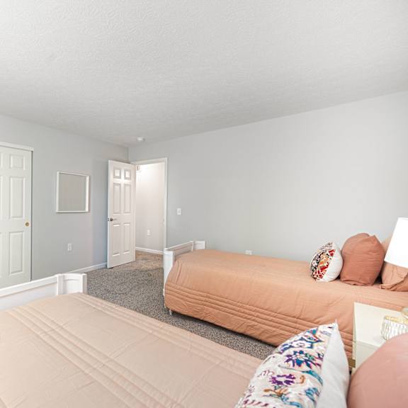a bedroom with two beds and a chair and a table