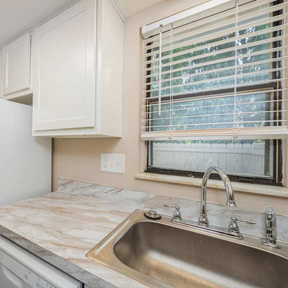 a kitchen with a sink and refrigerator and a window