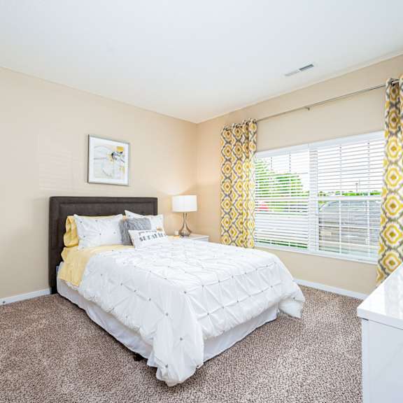 a bedroom with a bed and a large window