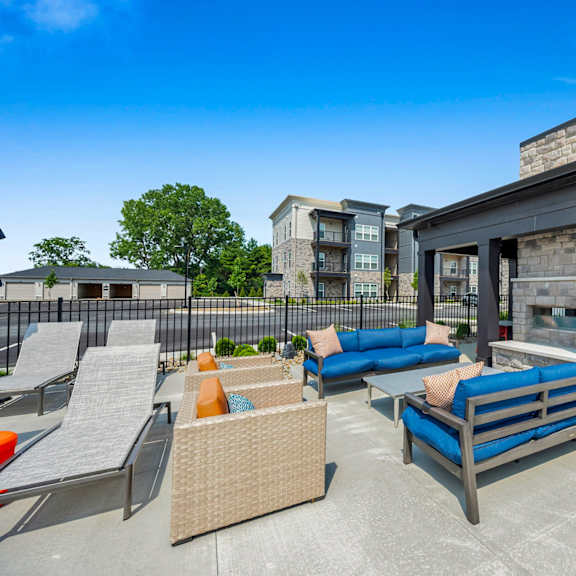 a patio with a blue couch and chairs.