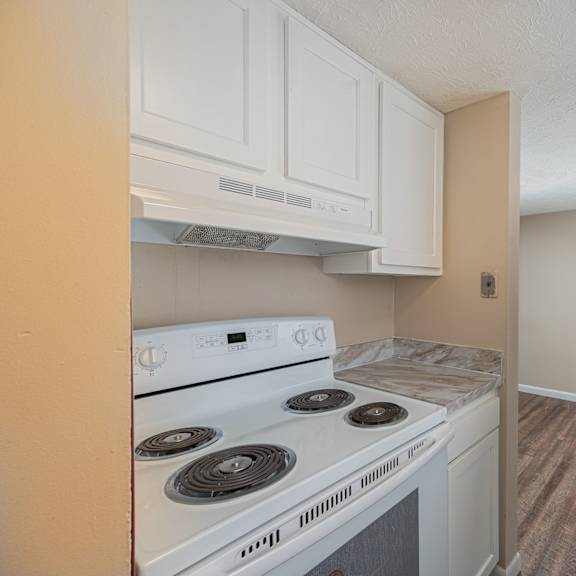 a kitchen with white cabinets and a stove and a refrigerator