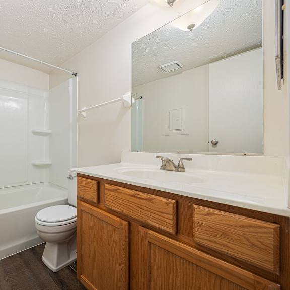 a white bathroom with a toilet, sink, and bathtub.