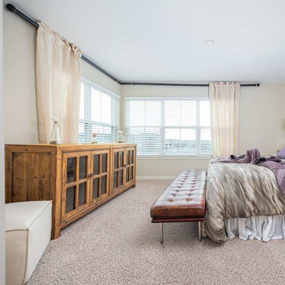 a bedroom with a large bed and a wooden cabinet.