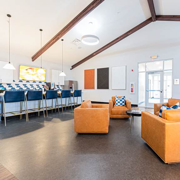 a room with orange ottomans and a white wall.