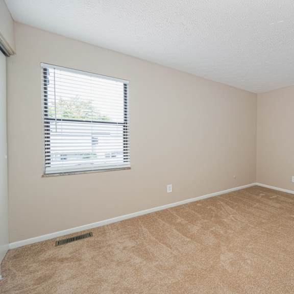 an empty room with carpet and a window