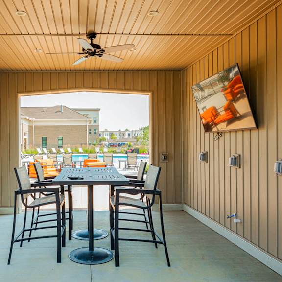 a patio with a table and chairs and a ceiling fan