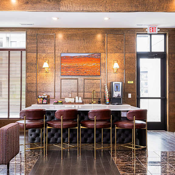 a bar with chairs and a marble table in a lobby