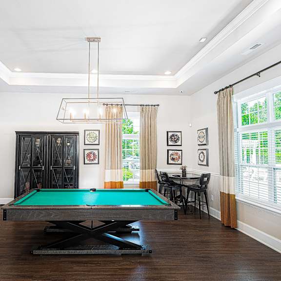 a living room with a pool table and a chandelier