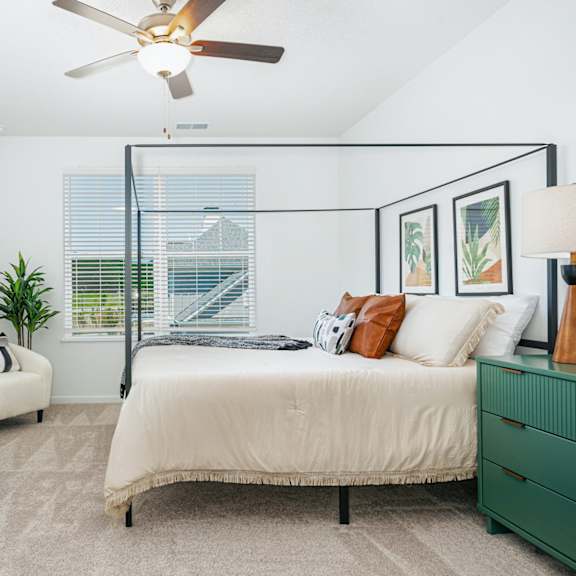 a bedroom with a bed and a ceiling fan