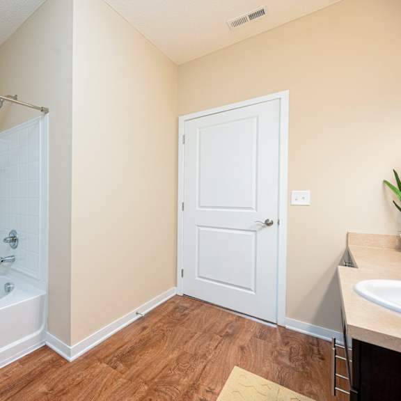 a bathroom with a tub and a shower and a sink