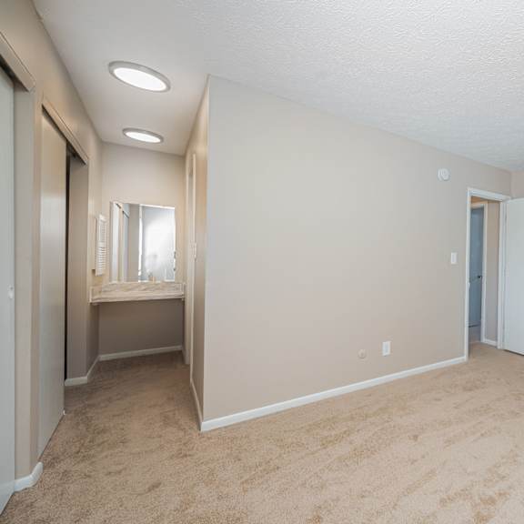 an empty living room with a bathroom and a closet