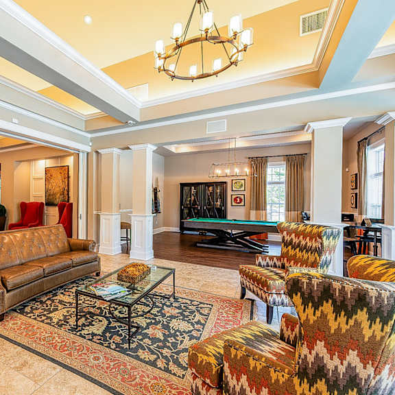 a living room with couches and a pool table