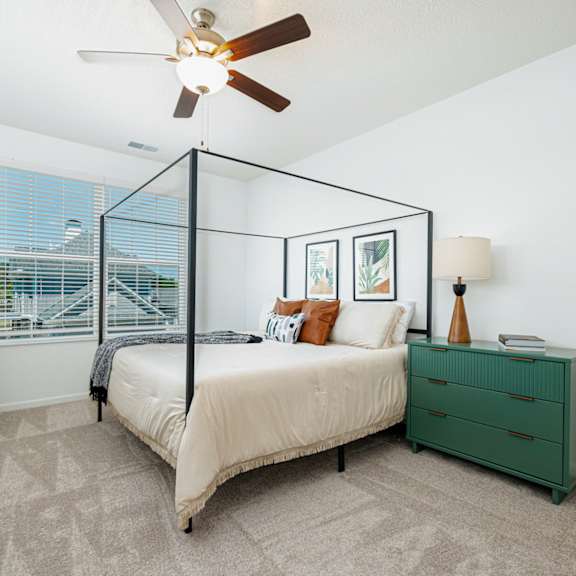 a bedroom with a bed and a ceiling fan