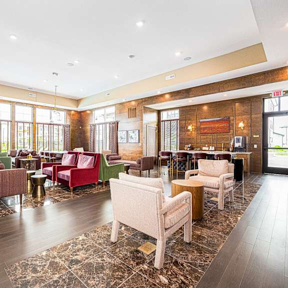 a lobby of a hotel with couches and chairs and a bar