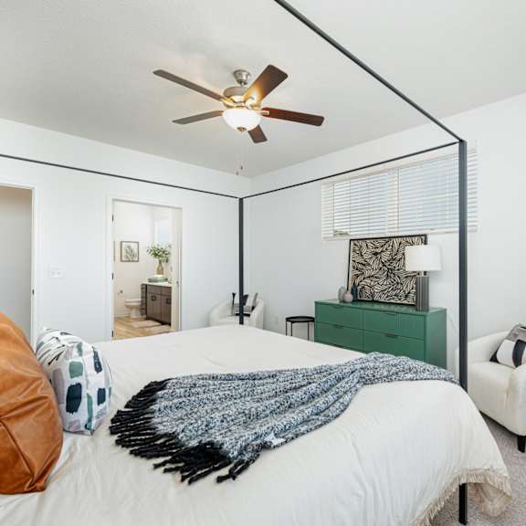 a bedroom with a large bed and a ceiling fan