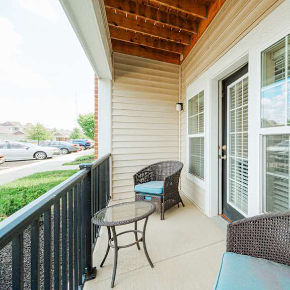 a porch with two chairs and a table and a large window