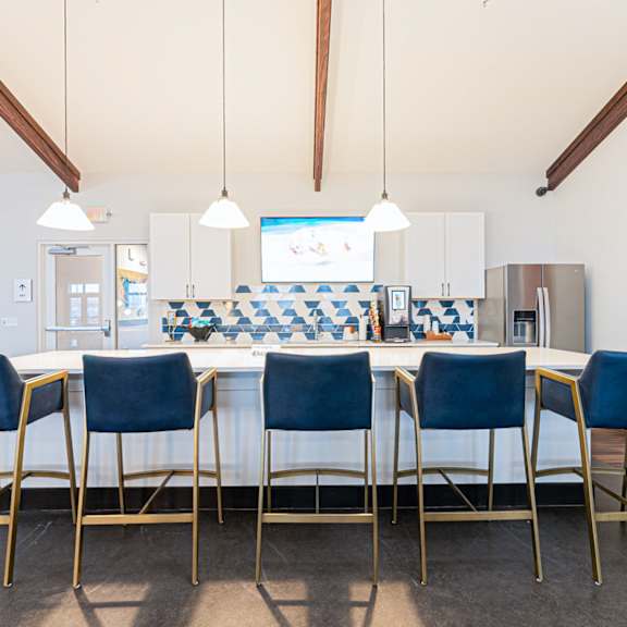 a dining room with a checkered tablecloth and blue chairs.