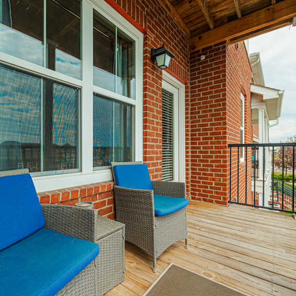a patio with chairs and a brick wall
