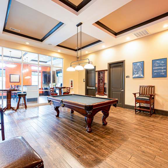 a game room with a pool table and a bar