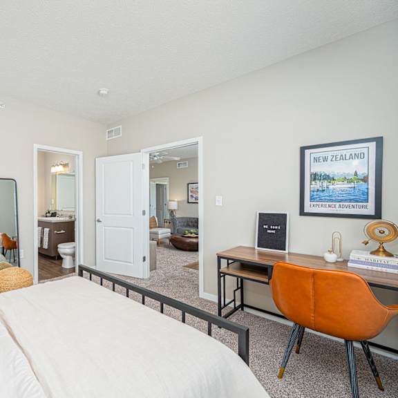 a bedroom with a bed and a desk with a mirror