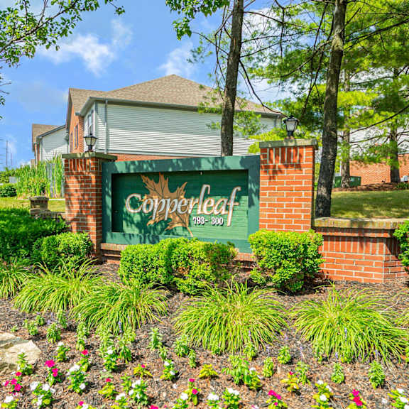 the sign for copperleaf apartments with trees and flowers