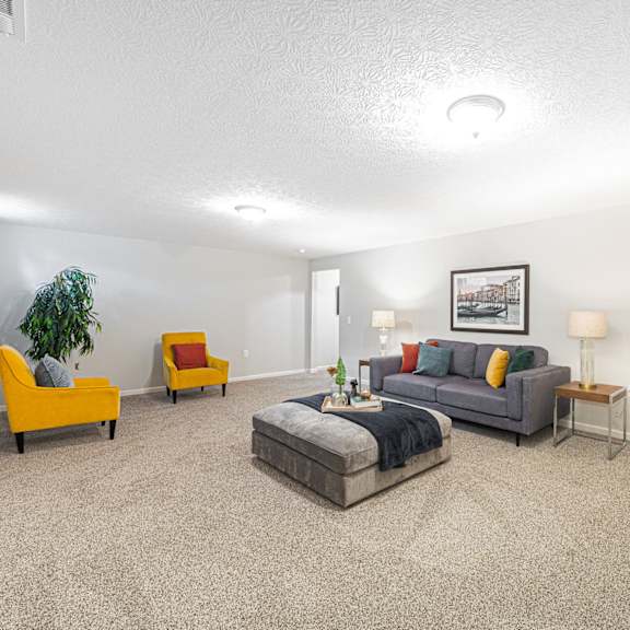 finished basement with a couch and chairs and a