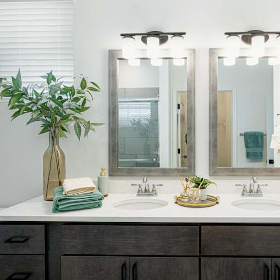 a bathroom with two sinks and three mirrors
