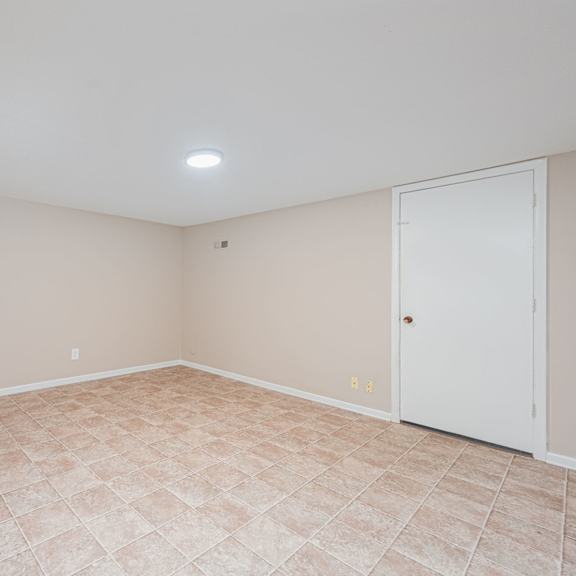 an empty living room with a door to a closet