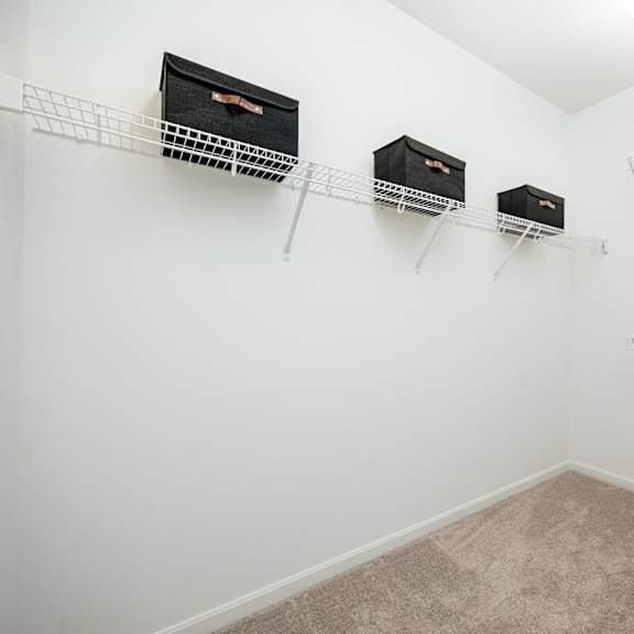 a spacious closet with shelves and hanging racks on the wall