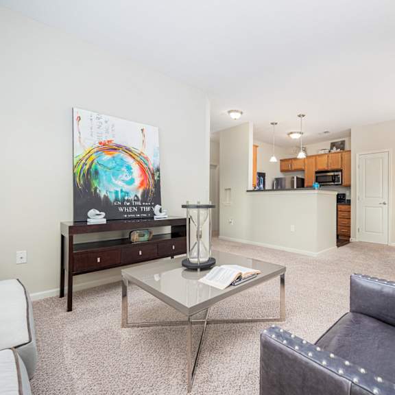 a living room with a grey couch and a glass coffee table.