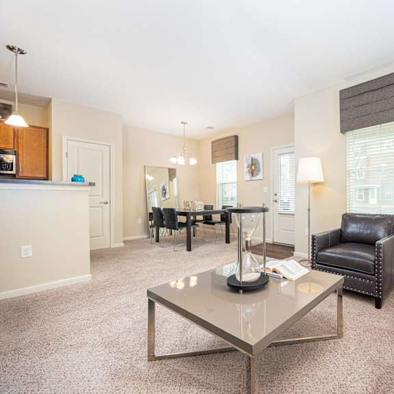 a living room with a glass coffee table in the center.