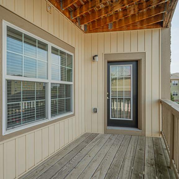 the front porch of a home with a door and windows