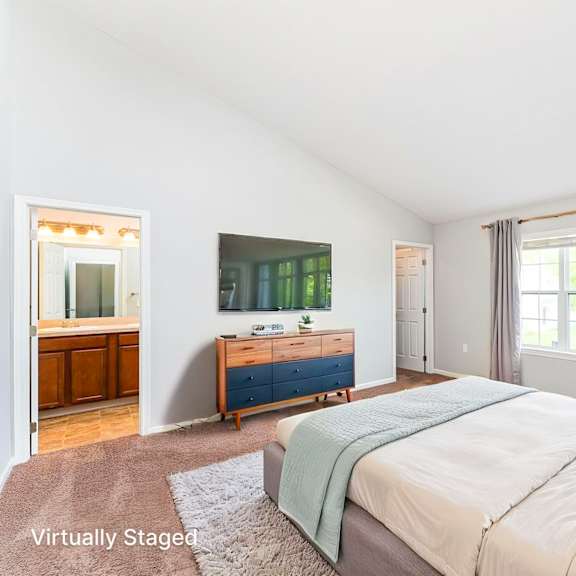 a bedroom with a bed, dresser, and window.