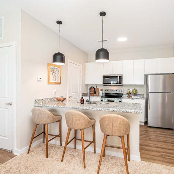 a kitchen with a marble counter top and bar stools